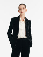 A lady wears a black velvet blazer.